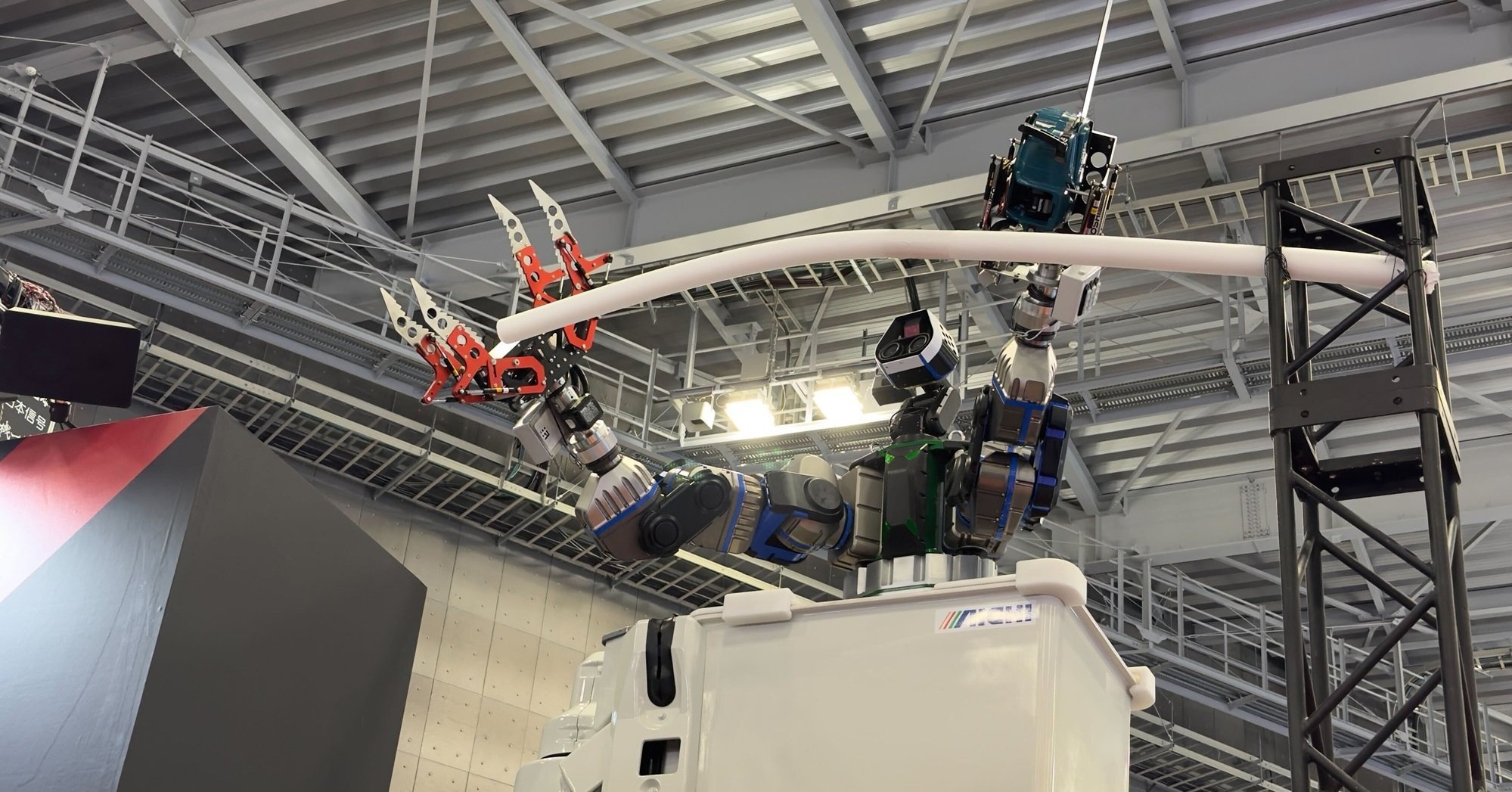 右手に巨大ヅメ、左手にチェーンソー 人々を高所から見下ろすロボット